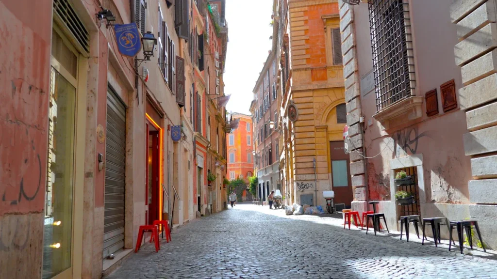 A sunlit narrow cobblestone street lined with historic buildings, representing a peaceful European town environment.