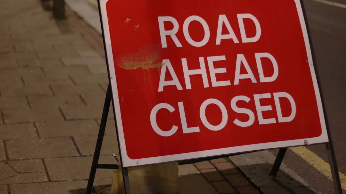 Road ahead closed sign on a paved London street at dusk.