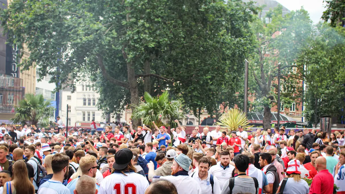 Large crowd of football fans gathering on a London street during the day.