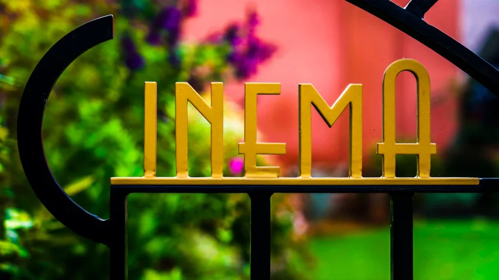 Close up of ironwork cinema signage in a public garden setting, Bournemouth, UK.