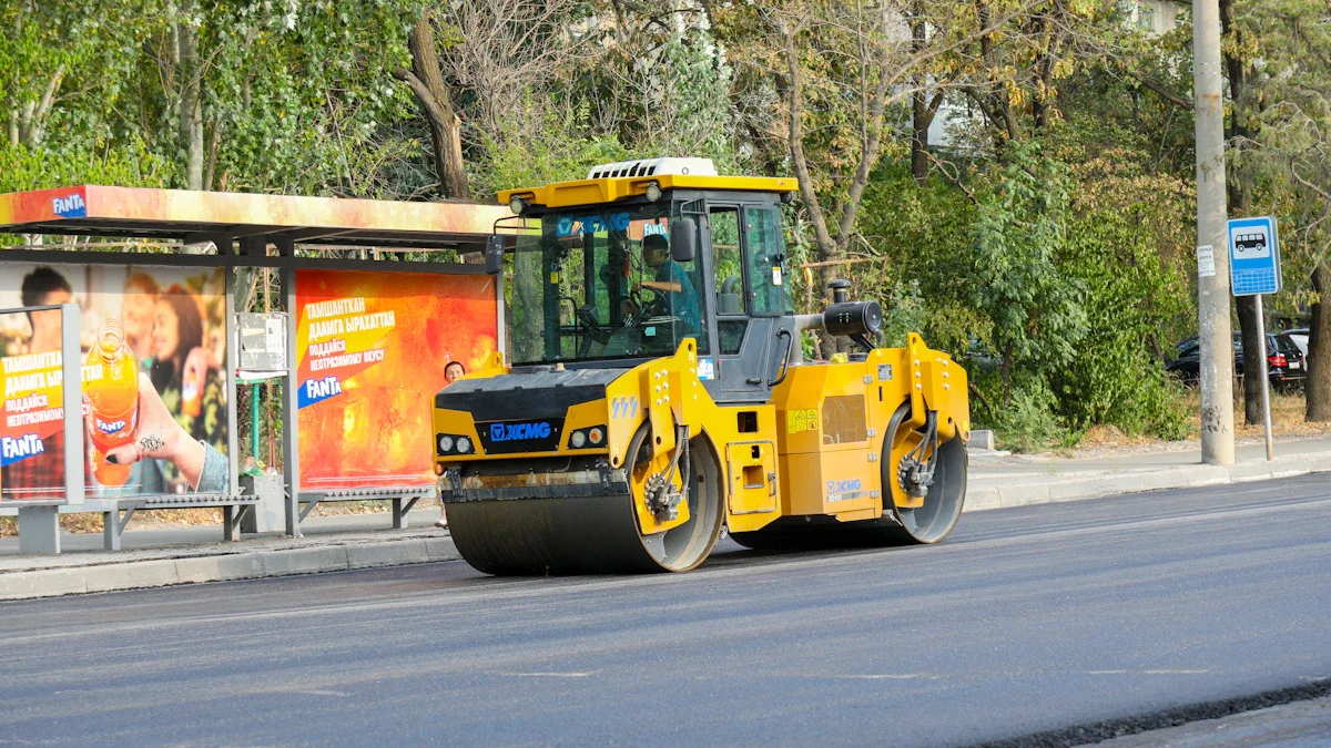 A yellow steamroller smoothing fresh asphalt on an urban street near a bus stop during a road resurfacing project.
