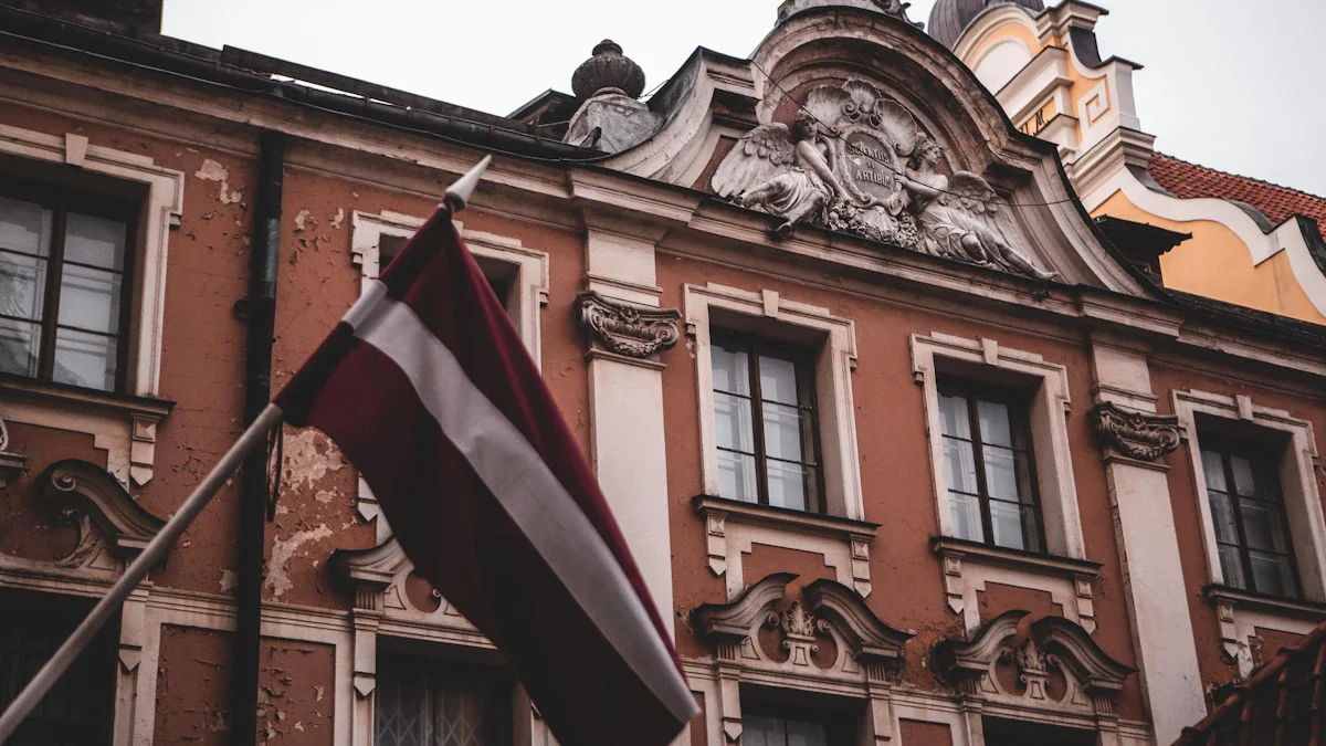 The national flag of Latvia waving in front of a historic, ornate European building in Riga.