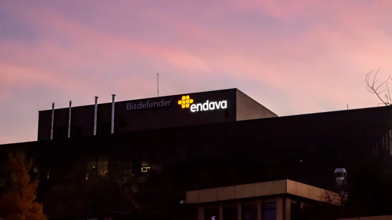 A modern corporate building at dusk featuring the glowing logos of cybersecurity and tech firms.