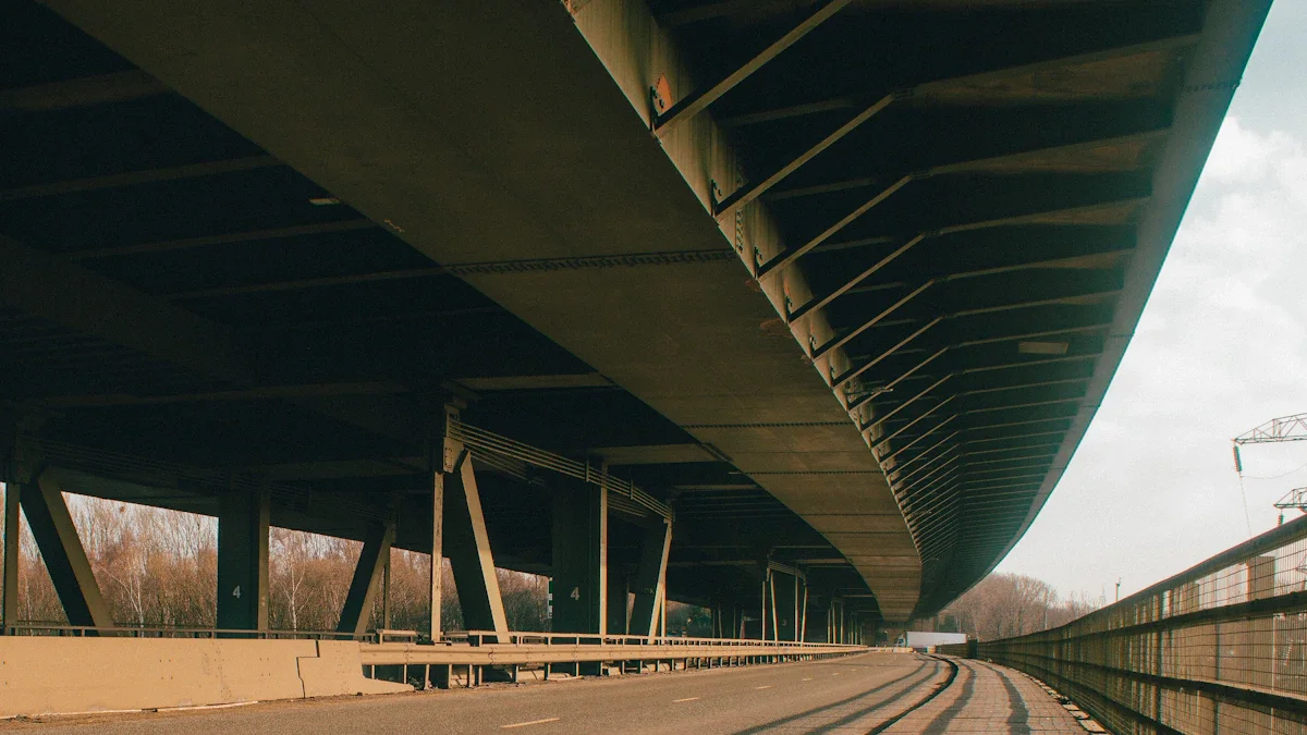 A view from beneath a massive concrete road viaduct showing the supporting structure and pillars.