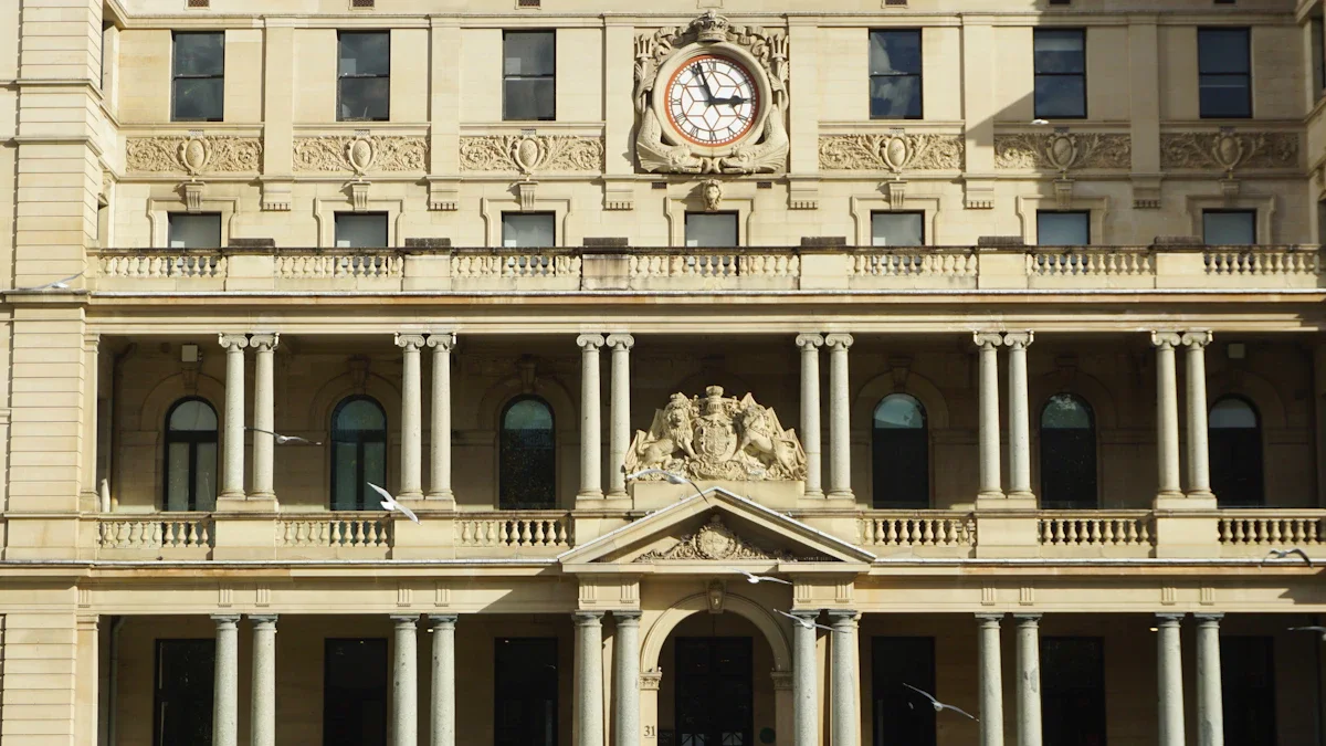 The ornate Neoclassical facade of a grand institutional building featuring a central clock and stone columns.