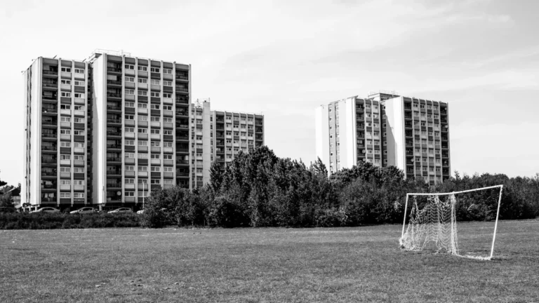 A black and white photograph of high-rise residential blocks in London across a grassy park.