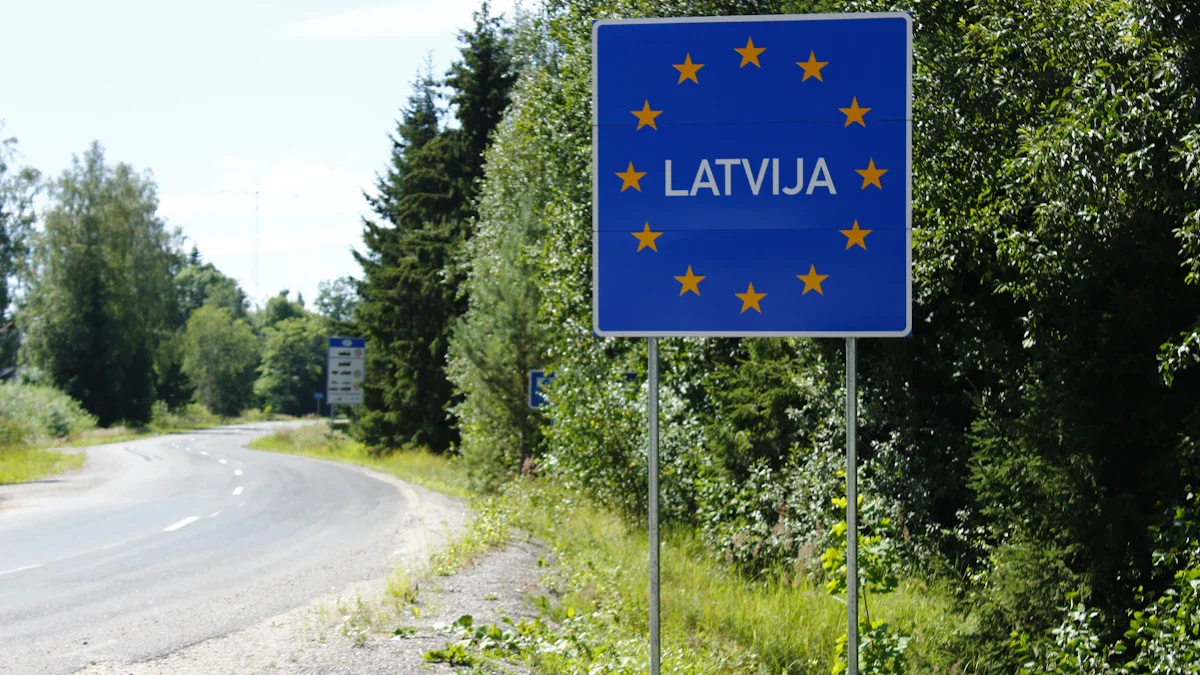 A blue road sign with yellow stars and the word 'Latvija' marks the Latvian border.