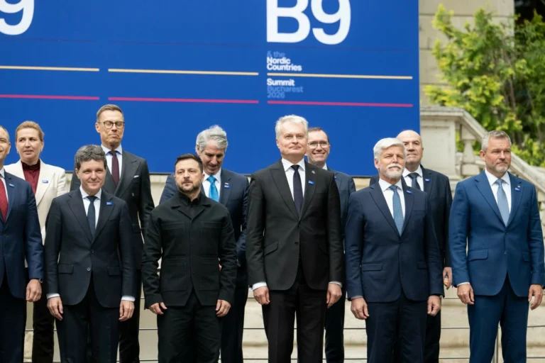 Volodymyr Zelenskyy and other European leaders stand before a blue B9 summit banner in Bucharest.