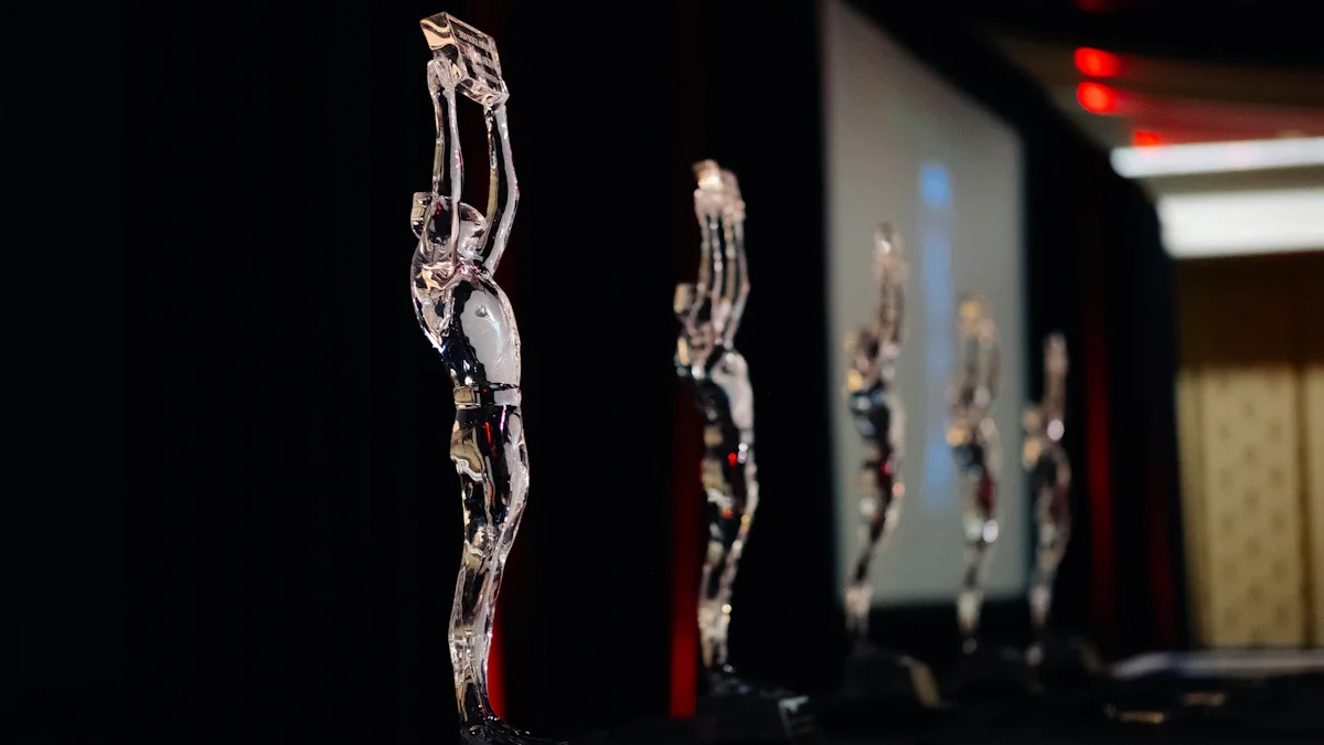 A row of elegant clear glass statuettes shaped like human figures on a dark stage.