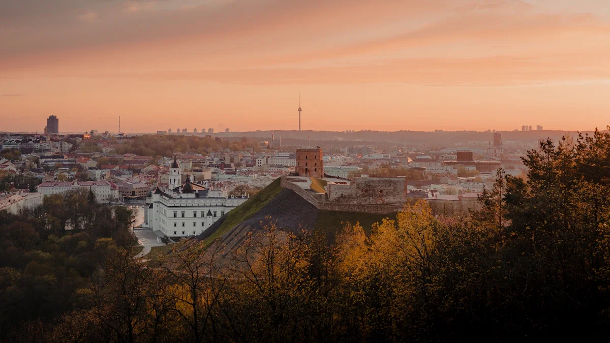 Panoramic sunset view over Vilnius, Lithuania, showing the Palace of the Grand Dukes and city landmarks.