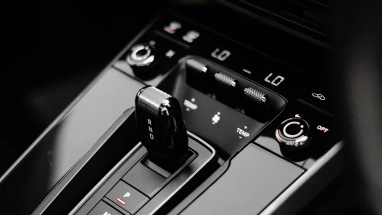 A sleek black and white close-up of a modern car's automatic gear shifter and center console.