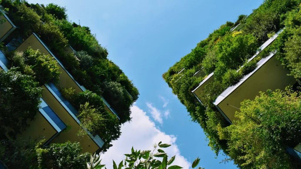 A low angle shot of modern apartment buildings in Europe with balconies covered in lush greenery.