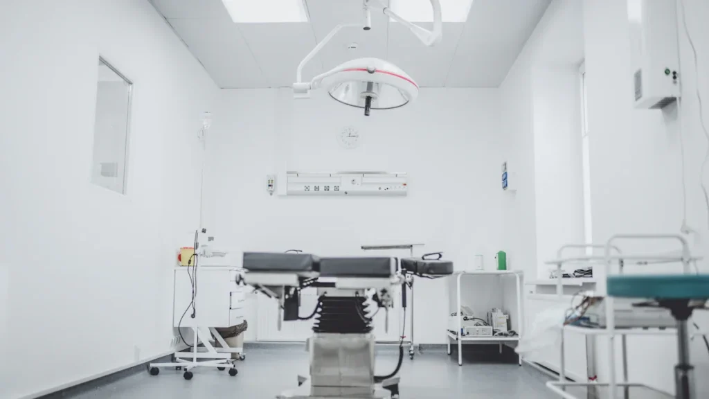 Modern black and white hospital room interior featuring a clinical bed and specialized medical lighting.