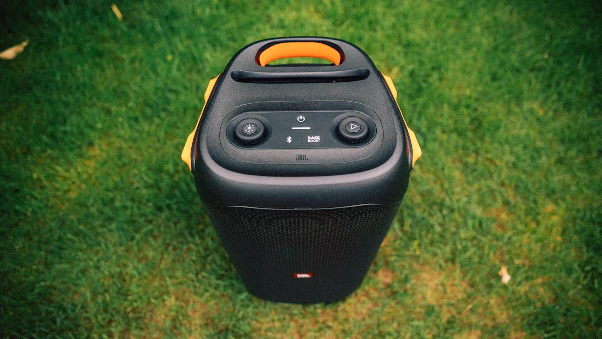 A large portable black party speaker sitting on a green lawn.