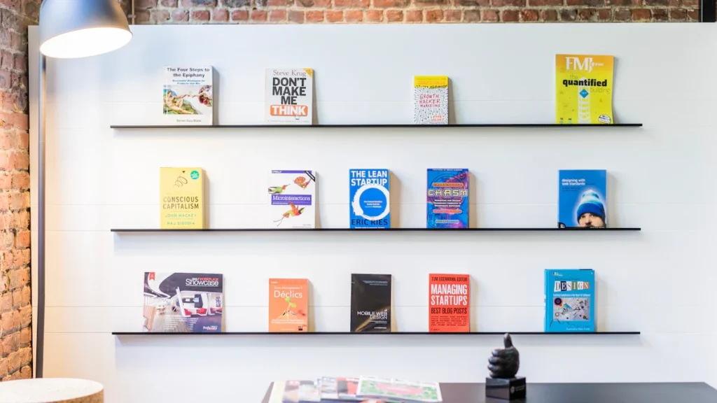 Selection of business books displayed on a clean modern library wall shelf.