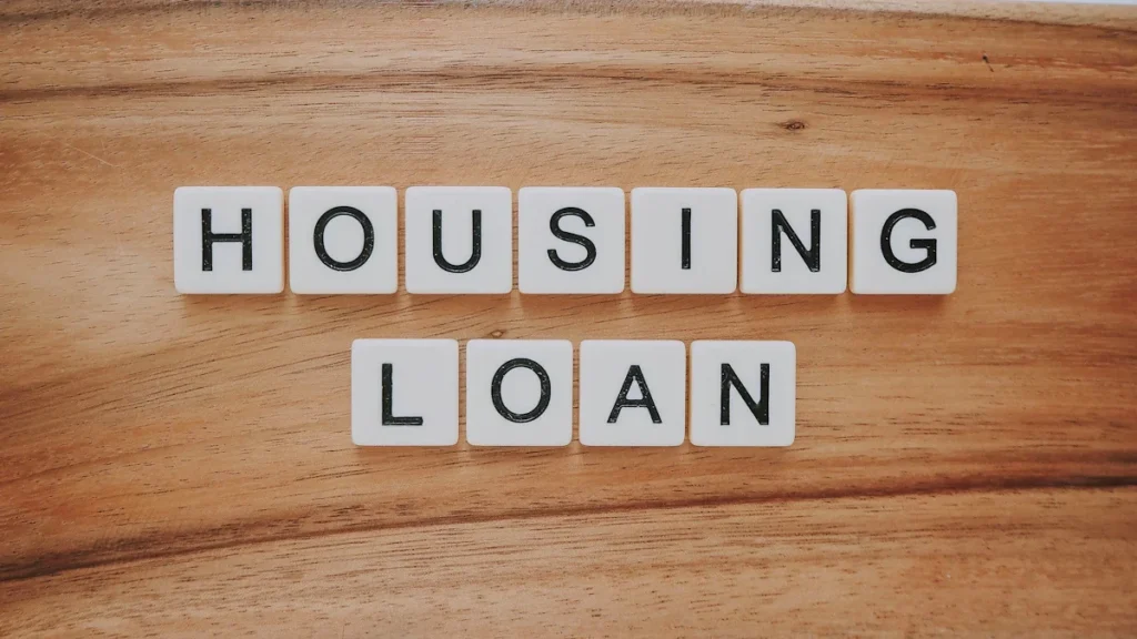 White letter tiles spelling 'HOUSING LOAN' on a brown wooden surface, representing financial aid options.