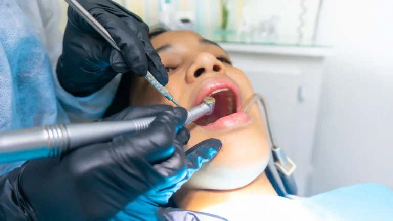 A close-up of a dentist using professional tools to treat a patient's teeth in a clinic.