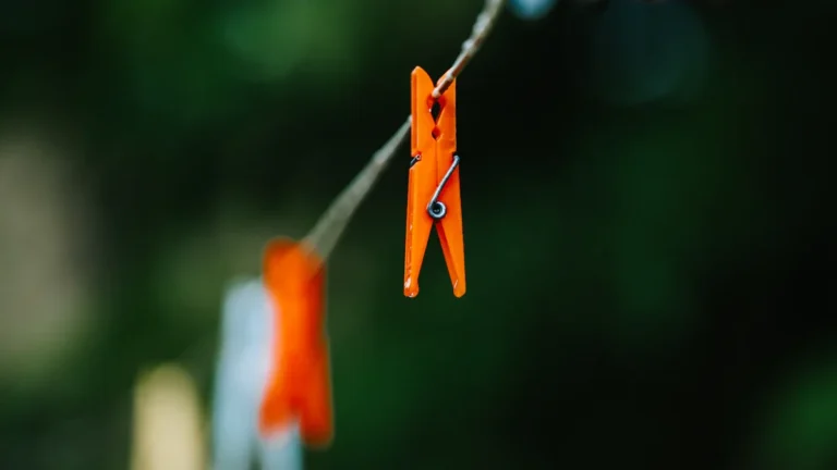 Close-up of an orange clothespin on a line, representing the Orange Button suicide prevention scheme.