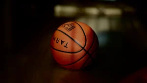 Close-up of a basketball on a dark surface, perfect for sports headlines.