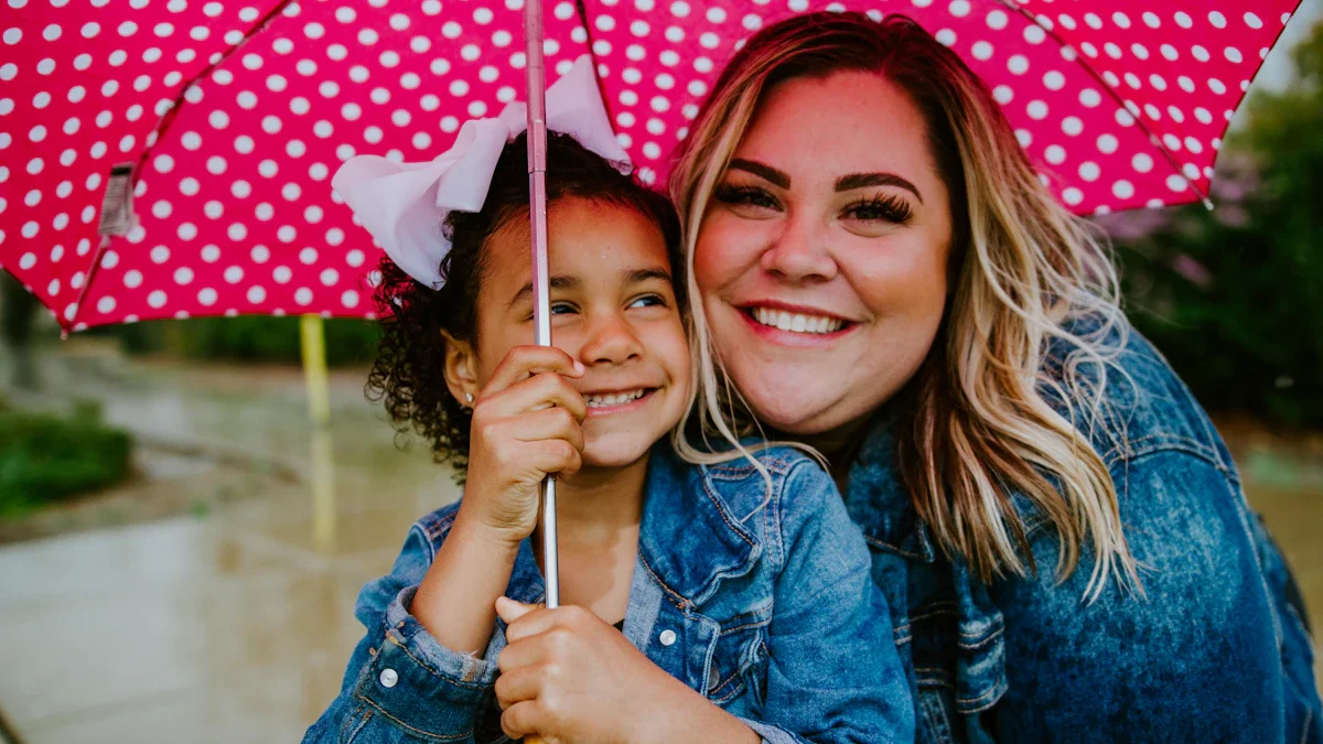 A smiling woman and a young girl sharing a pink polka-dot umbrella, representing a nurturing foster care relationship.