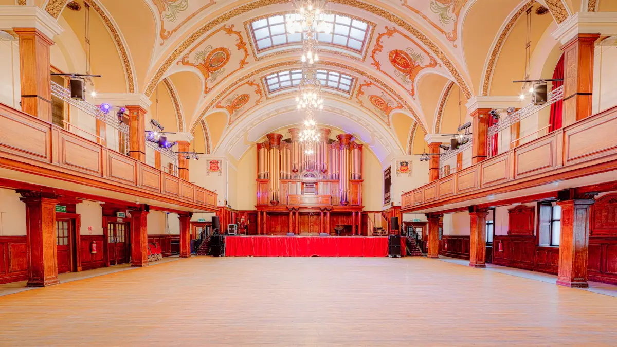Grand historic hall with an ornate pipe organ and high vaulted ceiling.