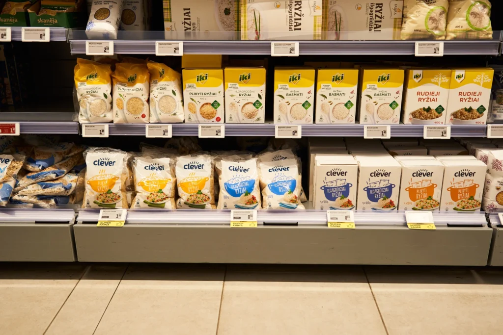 Neatly organized grocery store shelves displaying different brands and varieties of packaged rice products.