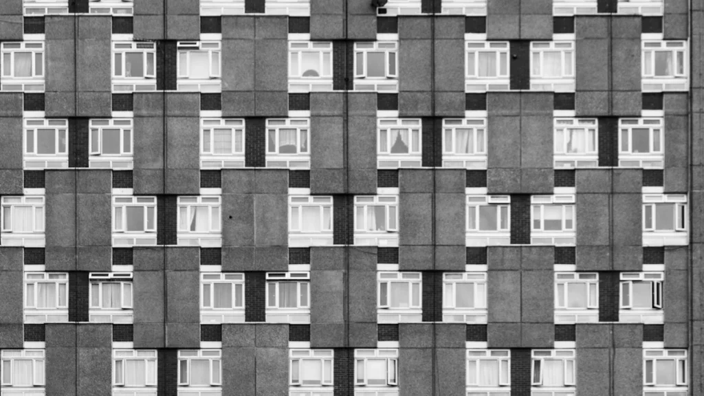 A black and white architectural close-up of a London Brutalist residential building facade.