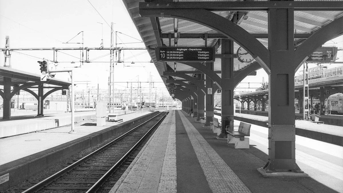 Black and white editorial shot of an empty train station platform and arched roof.