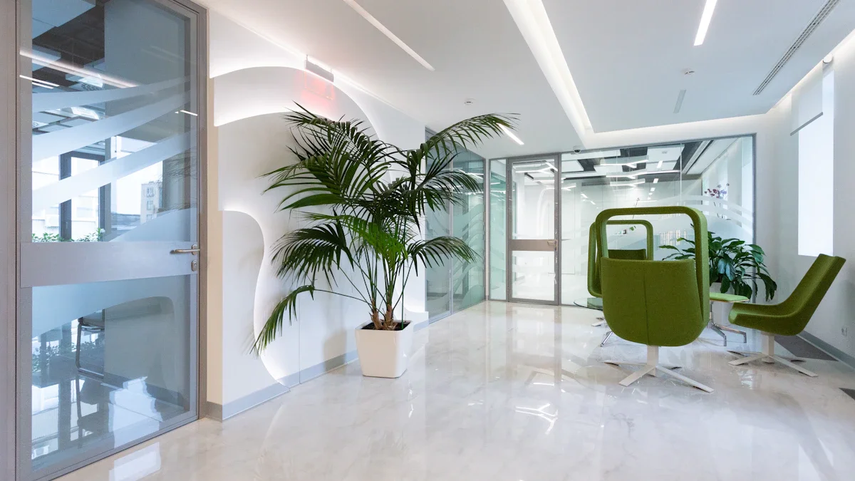 A bright modern waiting area with polished floors, a large potted plant, and green seating.