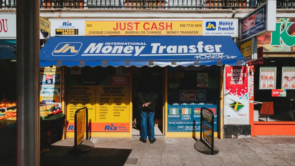 Storefront of a London money transfer shop with yellow and blue signage.