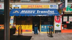 Storefront of a London money transfer shop with yellow and blue signage.