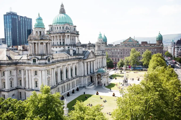 The grand Belfast City Hall building features a large green dome and public gardens.