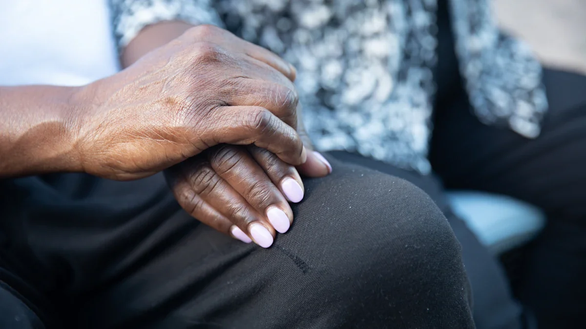 Close up of a person's hand resting gently on another person's lap.