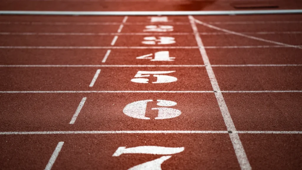 Close-up view of numbered running track lanes on a red athletic track.
