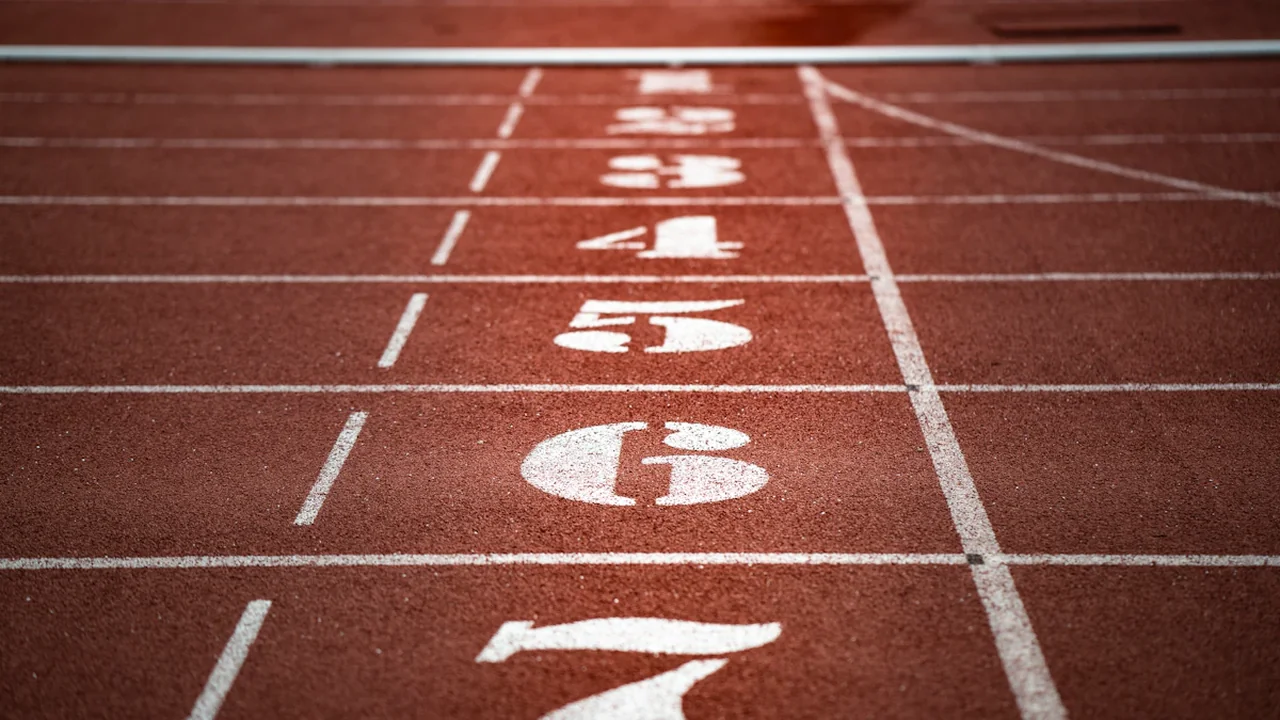 Close-up view of numbered running track lanes on a red athletic track.
