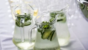 Clear glass pitchers filled with refreshing cucumber and mint infused sparkling water.