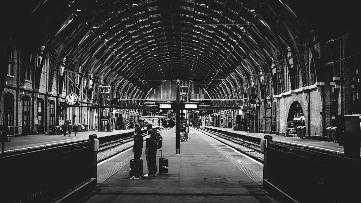 Black and white view of a busy train station platform with commuters.