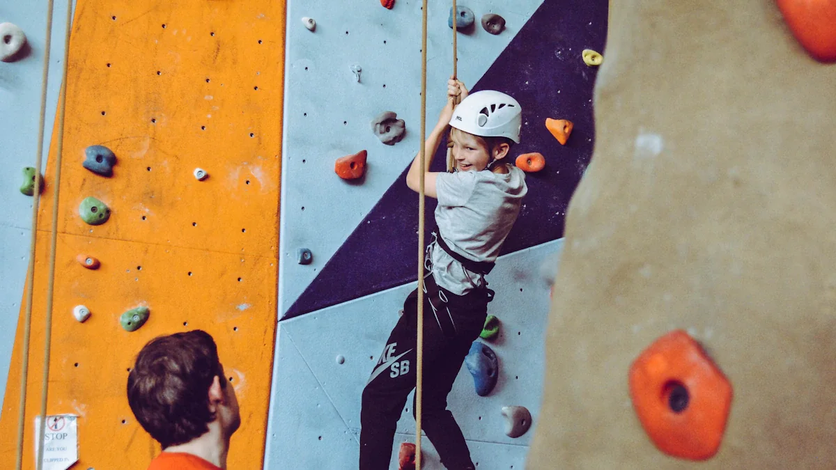Young boy wearing a climbing helmet scaling an indoor rock wall at a center.