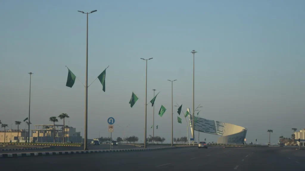 Street view in Saudi Arabia decorated with many green flags in the sunlight.