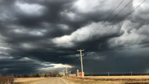 Dark, heavy storm clouds gathering over an open rural landscape in the countryside.